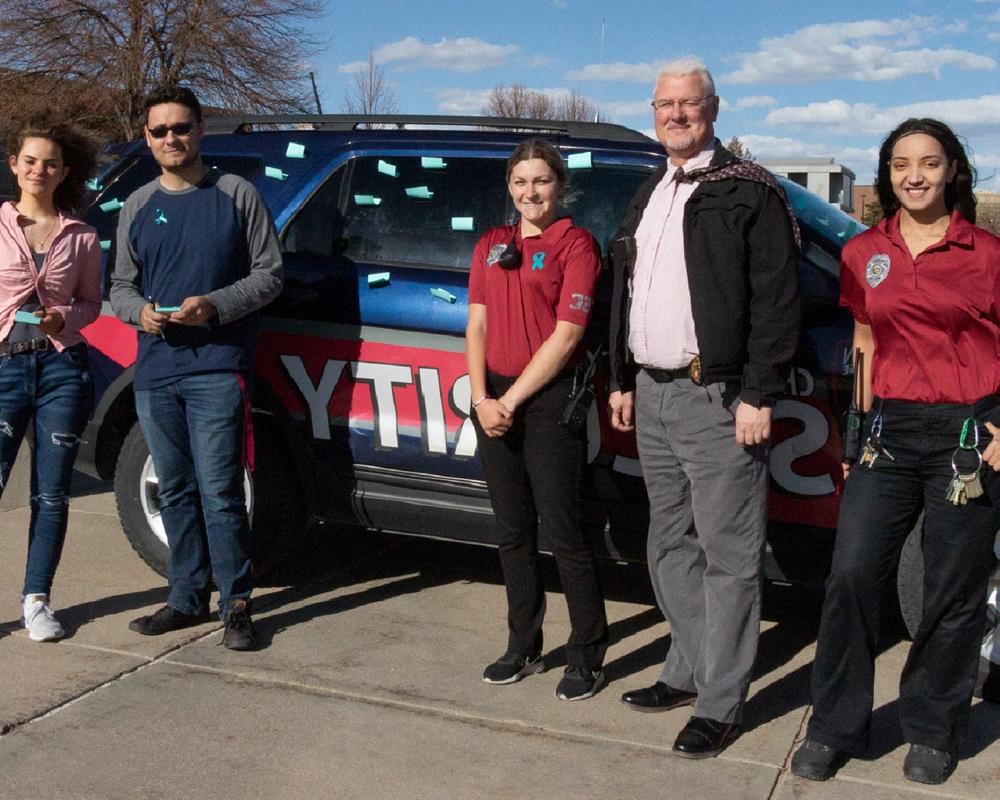 Photo of the campus security team next to one of their vehicles